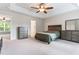 Expansive bedroom featuring a tray ceiling, ceiling fan, and ample natural light, providing a serene and inviting space at 822 Blue Lake Dr, Mebane, NC 27302
