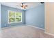 Comfortable bedroom featuring soft carpeting, a ceiling fan, ample natural light, and soothing blue walls at 822 Blue Lake Dr, Mebane, NC 27302