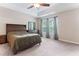 Spacious bedroom with a ceiling fan, tray ceiling, and large windows, offering a comfortable and bright atmosphere at 822 Blue Lake Dr, Mebane, NC 27302