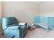 Inviting Bedroom featuring a soft recliner, a classic rocking horse, and a bright blue crib, perfect for a new arrival at 822 Blue Lake Dr, Mebane, NC 27302