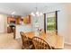 Bright dining area with an open view of the kitchen, featuring a wooden table, a view of the fenced yard, and an overhead light at 822 Blue Lake Dr, Mebane, NC 27302