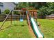 A wooden playset with a swing and slide in the backyard at 822 Blue Lake Dr, Mebane, NC 27302