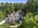 Stunning aerial view of a beautiful home surrounded by mature trees in a lush landscape at 8416 Davishire Dr, Raleigh, NC 27615