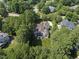 Aerial shot of a beautiful home surrounded by lush greenery, showcasing its backyard entertaining space at 8416 Davishire Dr, Raleigh, NC 27615