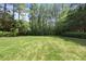 Expansive backyard featuring a well-manicured lawn and mature trees at 8416 Davishire Dr, Raleigh, NC 27615