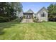 Back exterior view of home with a large deck and patio areas overlooking lush lawn at 8416 Davishire Dr, Raleigh, NC 27615