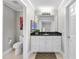 Bright bathroom with white cabinets, black countertop, and a toilet to the left at 8416 Davishire Dr, Raleigh, NC 27615