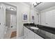 Bathroom with a black granite countertop and white vanity with access to the hallway at 8416 Davishire Dr, Raleigh, NC 27615