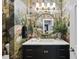 Unique powder room featuring colorful wallpaper, a round mirror with marble countertop, and a black vanity at 8416 Davishire Dr, Raleigh, NC 27615