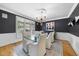 Formal dining room featuring dark walls, a glass table, and stylish chandelier at 8416 Davishire Dr, Raleigh, NC 27615