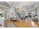 Bright foyer with a sweeping staircase, hardwood floors, and views into the living room at 8416 Davishire Dr, Raleigh, NC 27615
