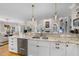Bright kitchen boasts white cabinets, stone countertops, stainless steel appliances, and modern pendant lighting at 8416 Davishire Dr, Raleigh, NC 27615