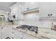 Close-up of kitchen featuring a modern cooktop set into granite countertops and white cabinetry at 8416 Davishire Dr, Raleigh, NC 27615