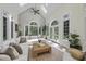 Bright living room with vaulted ceiling, large windows, neutral decor, and access to the outdoor space at 8416 Davishire Dr, Raleigh, NC 27615