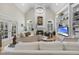 Bright living room with cathedral ceilings, fireplace, built-in shelving, and a large chandelier at 8416 Davishire Dr, Raleigh, NC 27615