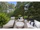 Inviting outdoor patio with lounge chair and comfortable wicker seating surrounded by lush greenery at 8416 Davishire Dr, Raleigh, NC 27615