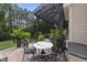 Charming patio with dark pergola, marble-topped table and patterned chairs at 8416 Davishire Dr, Raleigh, NC 27615