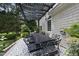 Inviting outdoor patio with a black pergola and dining table with seating at 8416 Davishire Dr, Raleigh, NC 27615