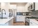 Modern kitchen with stainless steel appliances, dark backsplash, and a light countertop at 88 Freedom Heights Ln # 148, Smithfield, NC 27577