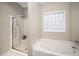 Bathroom featuring a glass-enclosed shower, soaking tub, and natural light, creating a tranquil and functional space at 904 E Ivy Valley Dr, Fuquay Varina, NC 27526