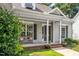 Inviting covered front porch with a comfortable bench, elegant columns, and manicured landscaping at 904 E Ivy Valley Dr, Fuquay Varina, NC 27526
