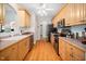 Efficient kitchen with wood cabinets, stainless appliances, and tile backsplash, offering practicality and style for cooking enthusiasts at 904 E Ivy Valley Dr, Fuquay Varina, NC 27526