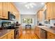 Charming kitchen boasts wooden cabinets, hardwood floors, and ample counter space, perfect for culinary adventures and hosting guests at 904 E Ivy Valley Dr, Fuquay Varina, NC 27526