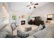 Bright and airy living room featuring a fireplace, large windows, a comfortable sofa, and a ceiling fan at 904 E Ivy Valley Dr, Fuquay Varina, NC 27526