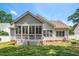 Back of house with screened-in porch, brick foundation and outdoor bench amidst green lawn at 904 E Ivy Valley Dr, Fuquay Varina, NC 27526