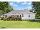 Charming back exterior featuring a spacious deck, manicured lawn, white siding, and mature landscaping in a desirable neighborhood at 904 Parkridge Dr, Clayton, NC 27527
