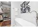 Bright bathroom features a modern soaking tub, stylish art, and organized storage at 904 Parkridge Dr, Clayton, NC 27527