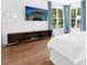 Light-filled bedroom with light wood floors, television, and serene outdoor views at 904 Parkridge Dr, Clayton, NC 27527