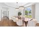 Bright dining room featuring hardwood floors, modern chandeliers, large windows, and stylish decor at 904 Parkridge Dr, Clayton, NC 27527