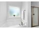 Clean bathroom showcasing a soaking tub with brushed nickel fixtures and a glass-enclosed shower at 93 Kinsale Ct, Garner, NC 27529