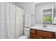 Neutral bathroom with a shower and tub featuring patterned curtains and a vanity with wood cabinets at 93 Kinsale Ct, Garner, NC 27529