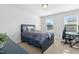 This bedroom has two windows for natural lighting, with a dark bed frame and matching desk at 93 Kinsale Ct, Garner, NC 27529