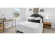 Stylized bedroom featuring tufted headboard, accent pillows, side table, and desk with natural light at 93 Kinsale Ct, Garner, NC 27529