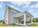 Back exterior of a two-story home with a covered patio, green lawn, and lush trees in the background at 93 Kinsale Ct, Garner, NC 27529