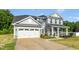 Charming two-story house with a wide driveway, attached garage, and inviting covered porch at 93 Kinsale Ct, Garner, NC 27529