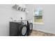 Efficient laundry room features a washer and dryer with storage shelves at 93 Kinsale Ct, Garner, NC 27529