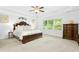 Spacious main bedroom features a large window with verdant view, tray ceiling and wood furniture at 93 Kinsale Ct, Garner, NC 27529