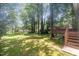 Expansive backyard featuring a deck, playground, mature trees, and plenty of space for outdoor enjoyment at 1008 Alderleaf Dr, Fuquay Varina, NC 27526