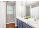 Bathroom with dual vanity sinks, wood look floors, and updated fixtures at 1008 Alderleaf Dr, Fuquay Varina, NC 27526