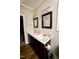 Bathroom featuring a vanity with double sinks, wood flooring, two black-framed mirrors, and a toilet paper holder at 102 Bluegrass Dr, Oxford, NC 27565