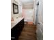 Bathroom featuring a vanity with double sinks, wood flooring, a toilet, and a tub with a shower at 102 Bluegrass Dr, Oxford, NC 27565