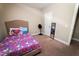 A bedroom featuring neutral walls, a carpet, a bed with a cartoon-themed comforter, and a full length mirror at 102 Bluegrass Dr, Oxford, NC 27565