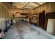 An unfinished garage interior with unpainted drywall, bare floors, tables, shelves, and storage at 102 Bluegrass Dr, Oxford, NC 27565
