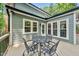 Comfortable outdoor seating on back porch with paneled windows and neutral siding at 1030 W Sterlington Pl, Apex, NC 27502