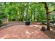Charming brick patio offers ample space with an outdoor grill and a beautiful view of the wooded backyard at 1030 W Sterlington Pl, Apex, NC 27502