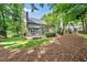 Wide backyard with green lawn, mature trees, wooden deck and a brick patio at 1030 W Sterlington Pl, Apex, NC 27502